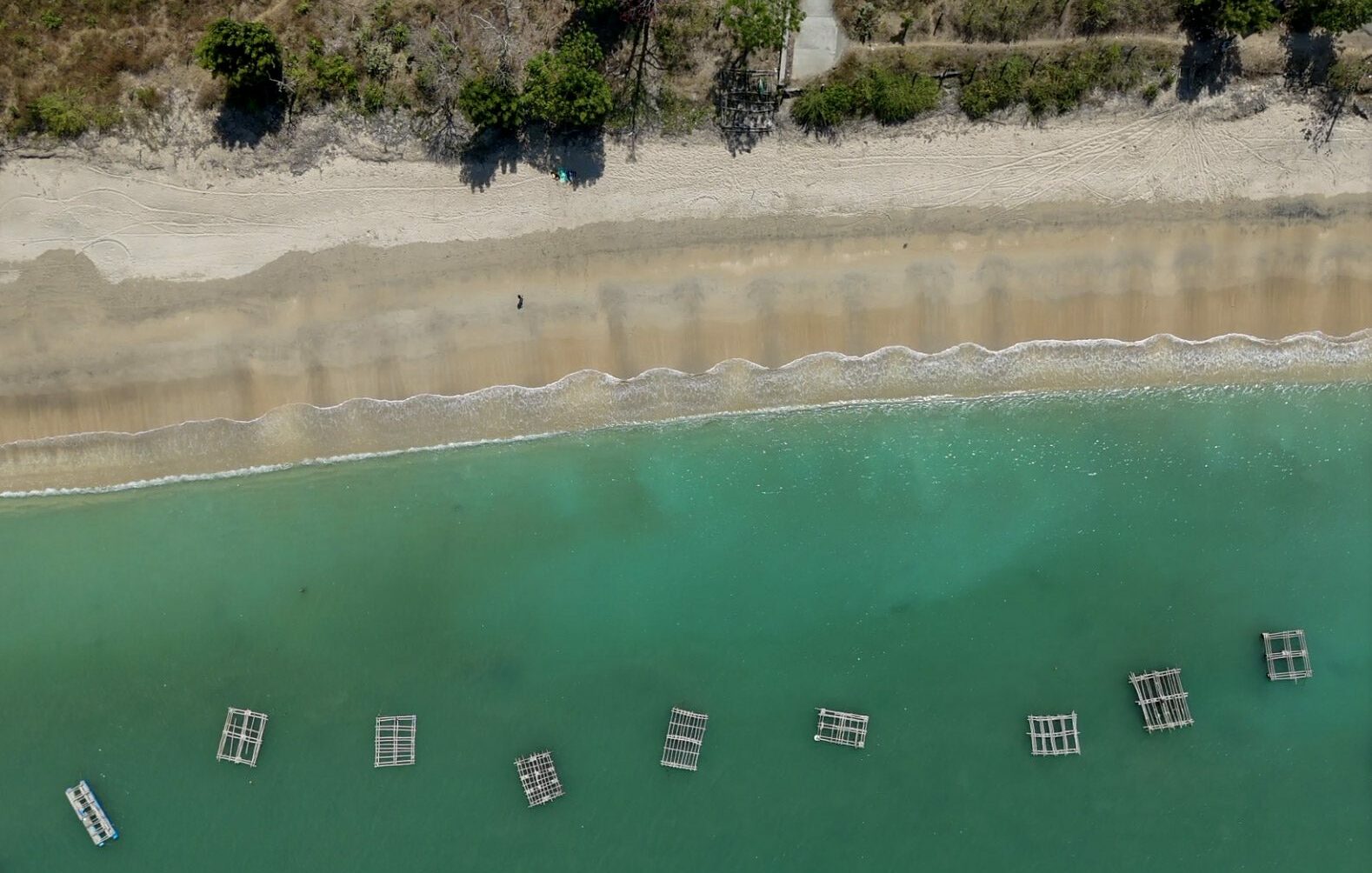 Plage à Gerupuk: sauvage et presque vide à Lombok, sable clair et eau turquoise bordée de collines verdoyantes.